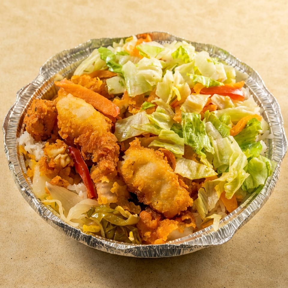 Foil bowl filled with crispy fried chicken, white rice, sautéed vegetables, and fresh lettuce salad.